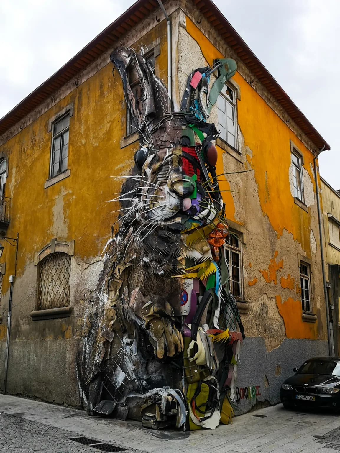 Picture of a giant, dark gothic rabbit on the side of an orange building.